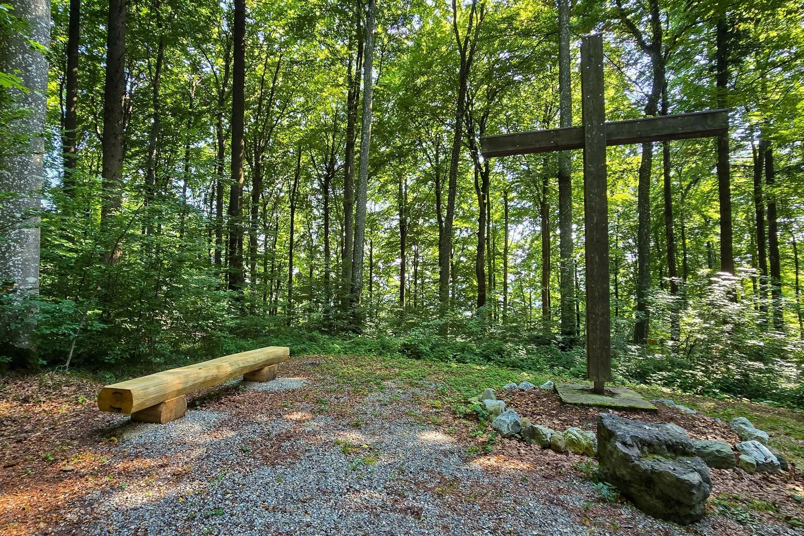 Eine Bank und ein Kreuz in einem Friedwald